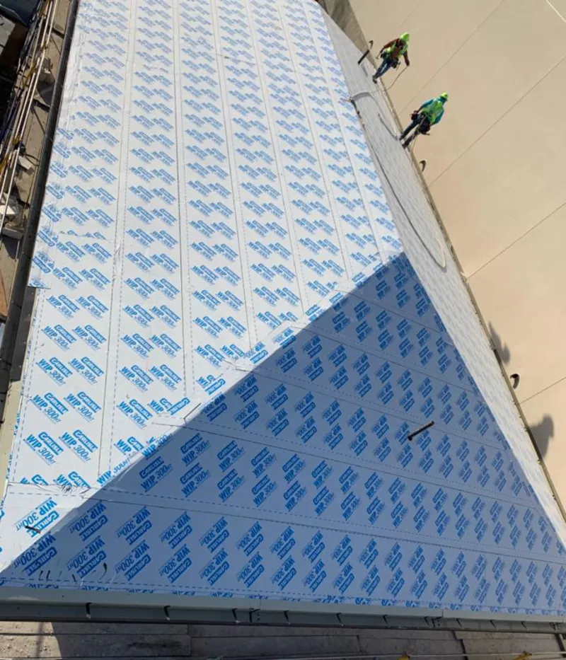 Professional roofers installing underlayment on a metal roof in Roseburg